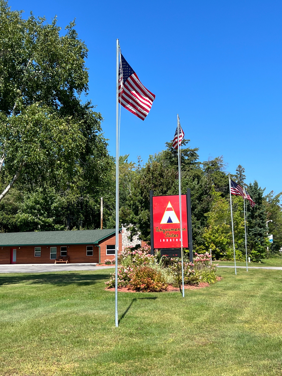 Tahquamenon suites hotel paradise Michigan welcoming front lawn with American flags